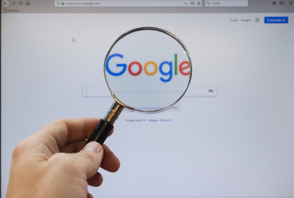 Magnifying glass and google logo on screen
